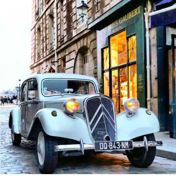 Vintage car transfer with private driver and Citroen Traction at Place Dauphine in front view
